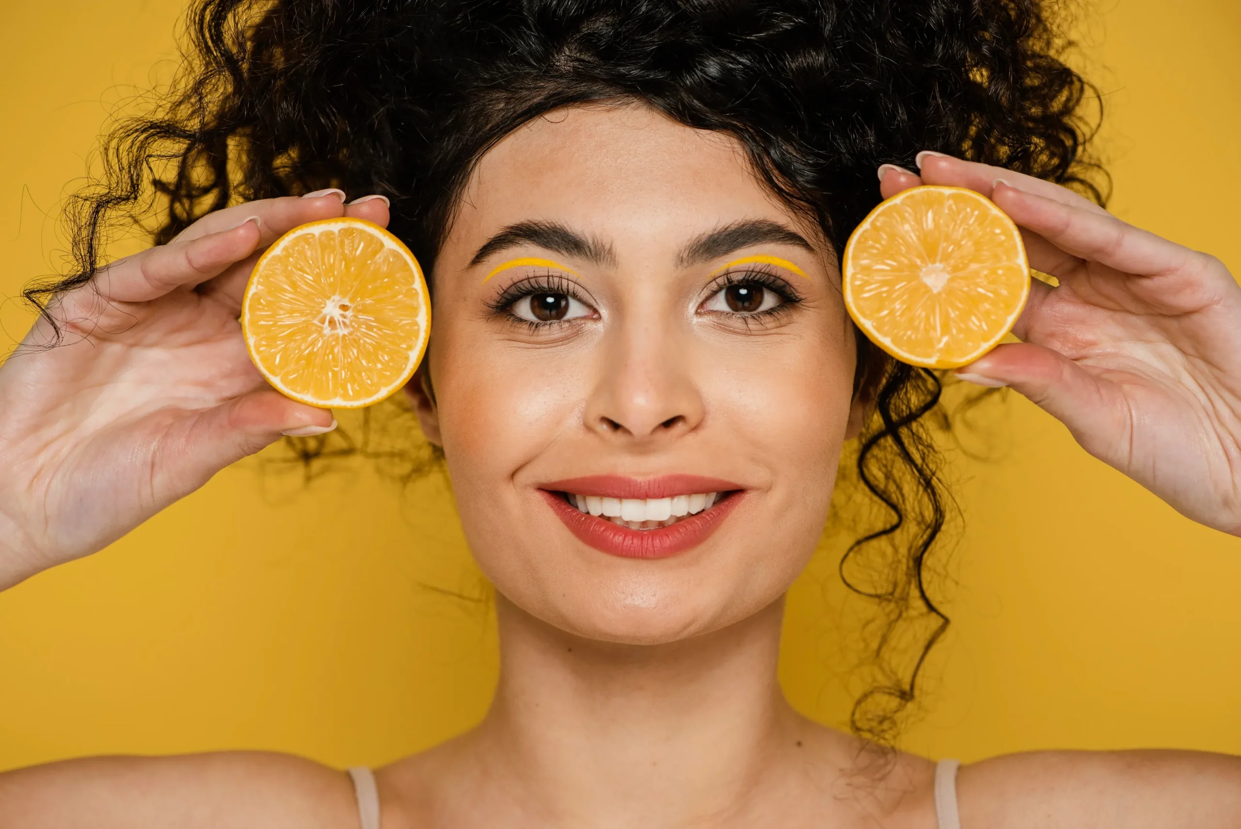 close-up-smiley-woman-holding-lemon-slices-converted-from-jpg