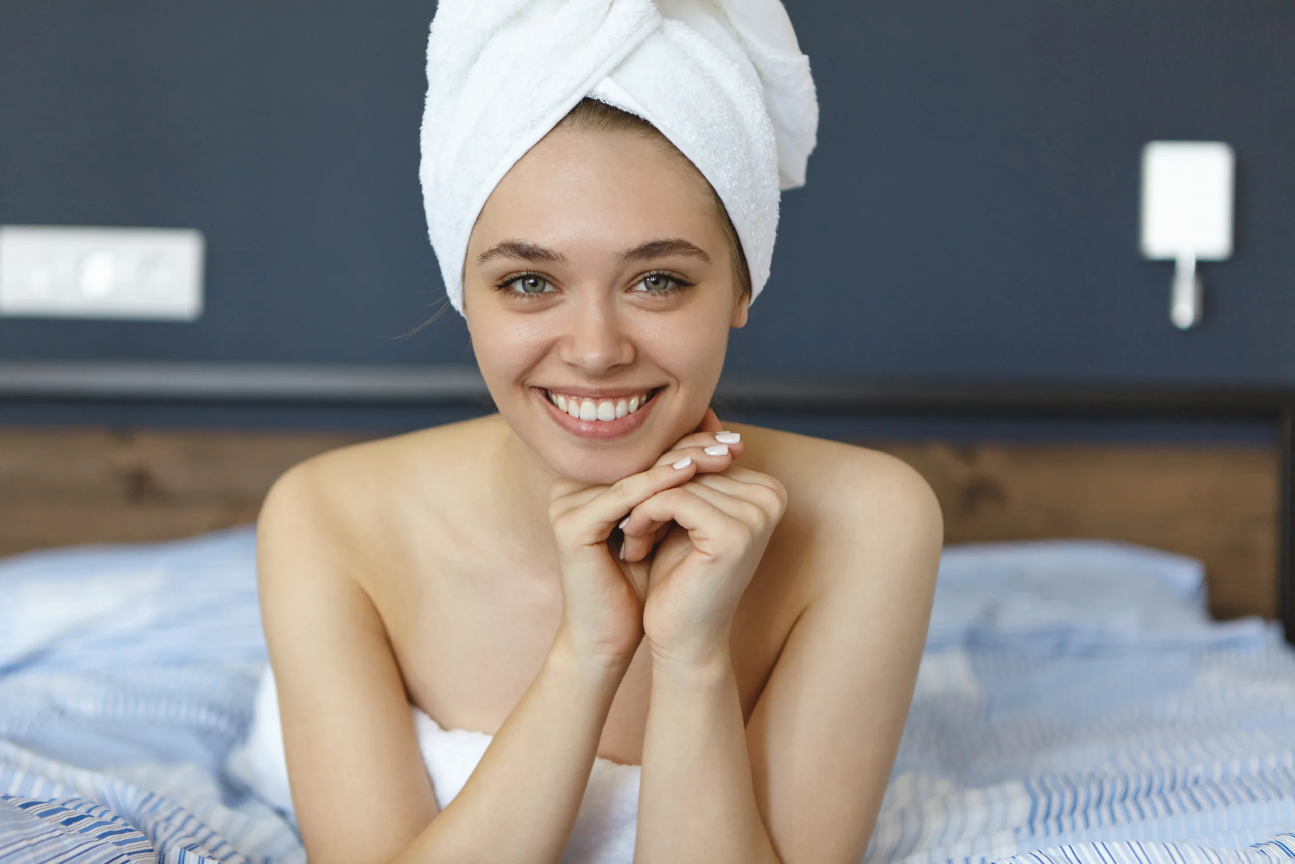 woman-sitting-bed-after-shower-wearing-towels